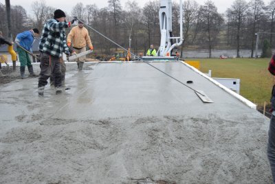 Hlazení povrchu čerstvého betonu pomocí latí, popř. vibrační latí.