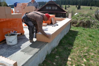 Zkušenosti z praxe ukazují, že nejlepším způsobem uložení první řady cihel je na jeden den vyzrálou zakládací maltu pro tenké spáry, zejména tehdy, pokud se cihly přesazují přes základovou desku. Pokud by byla malta čerstvá a měkká, mohlo by dojít k vyklonění cihel! Na zakládací maltu se nanese malta pro tenkou spáru, nebo 2 housenky tenkovrstvého PU lepidla a uloží se cihly do roviny vytyčené zednickou šňůrou. Cihly je též možné ukládat do čerstvé zakládací malty. 